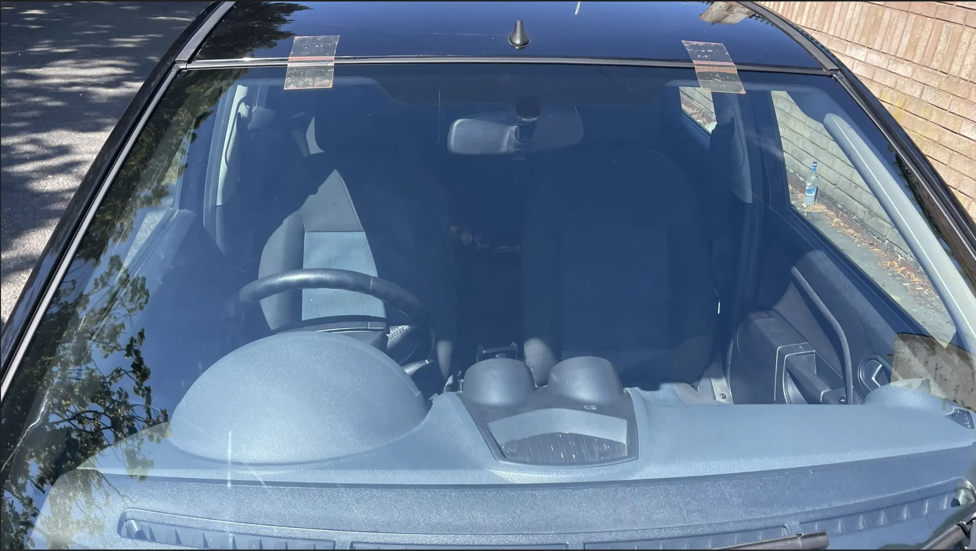 Technician checking trim and glass position after windscreen fitting